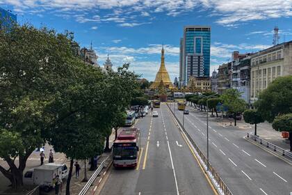 Autobuses públicos y taxis circulan por la calle Sula Pagoda, el domingo 24 de octubre de 2021, en Yangón, Myanmar. (AP Foto)