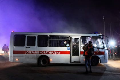Autobuses que transportan a los evacuados desde China en ida a una instalación médica mientras la policía despeja el camino de los manifestantes en el asentamiento de Novi Sanzhary el 20 de febrero de 2020.