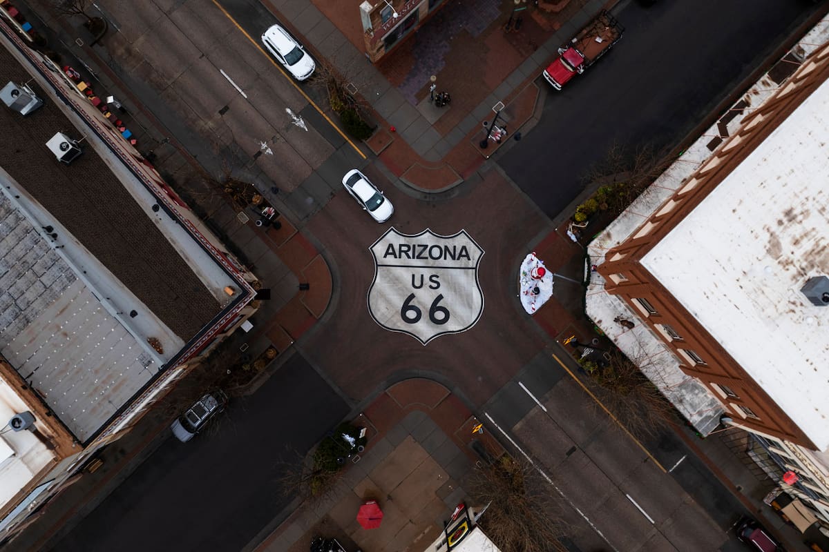 Automovilistas transitan por una intersección señalizada con el escudo de la U.S. 66 en Winslow, Arizona, una ciudad ubicada en la histórica carretera, el jueves 20 de noviembre de 2025. (Foto AP/Jae C. Hong)