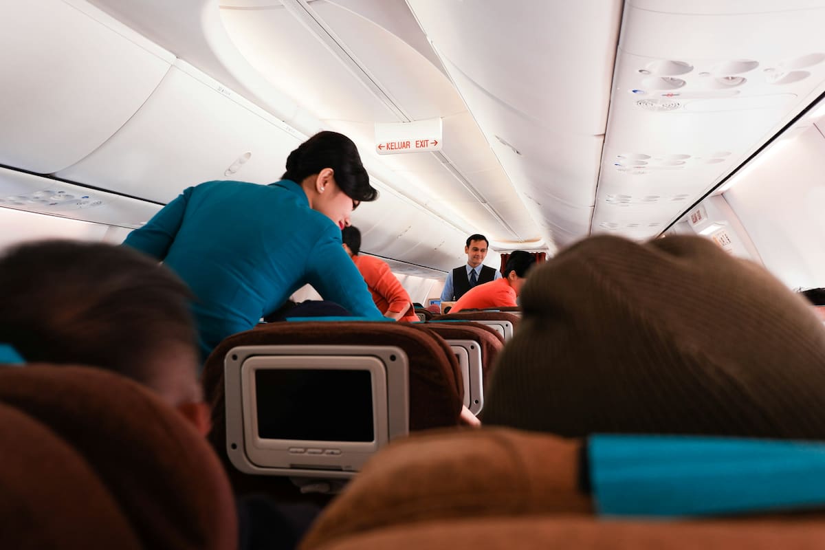 Auxiliares de vuelo asisten a los pasajeros durante el servicio a bordo, en un entorno donde el contacto físico no siempre es necesario