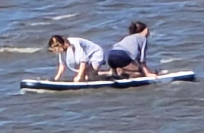 Avery Bryan y Eva Aponte con su tabla de paddleboard, horas antes de ser arrastradas por la corriente