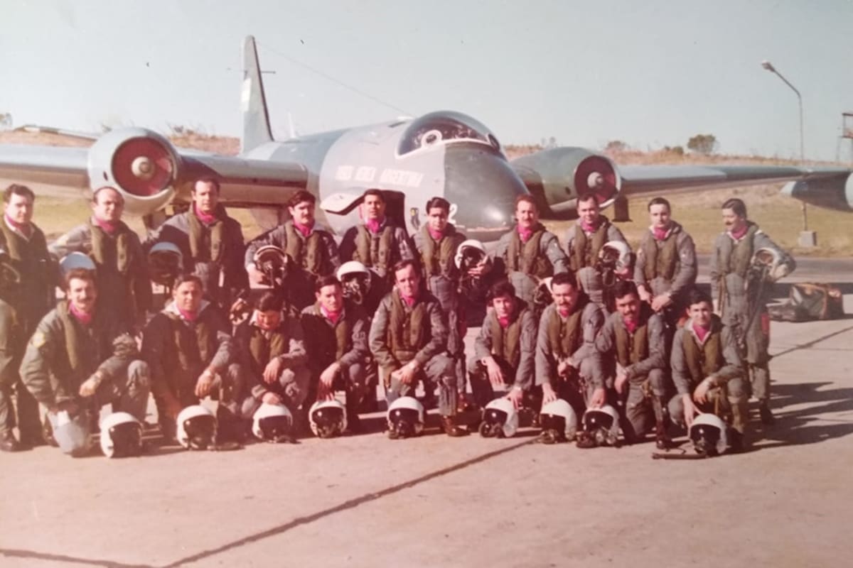 Aviadores argentinos con el pañuelo bordó en su cuello, que era distintivo del Escuadrón Canberra; en el fondo, un avión Canberra