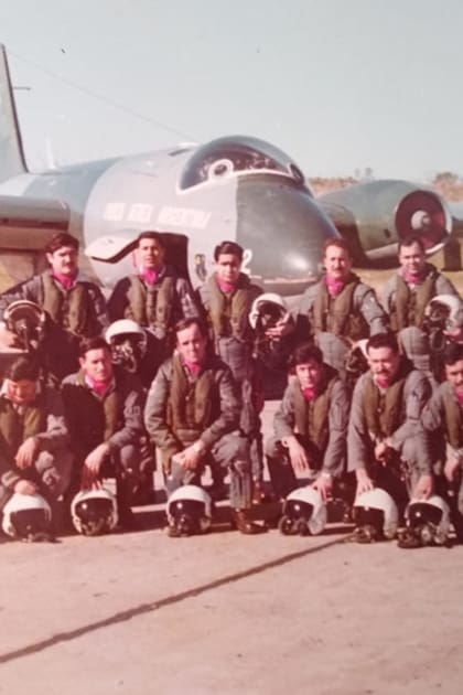 Aviadores argentinos con el pañuelo bordó en su cuello, que era distintivo del Escuadrón Canberra; en el fondo, un avión Canberra