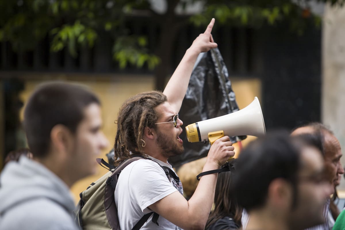 Badajoz, Spain - March 29, 2012: young demostrator with megaphone protesting against austerity cuts, March against the Labor Reform approved by the Government of Spain on March 2012