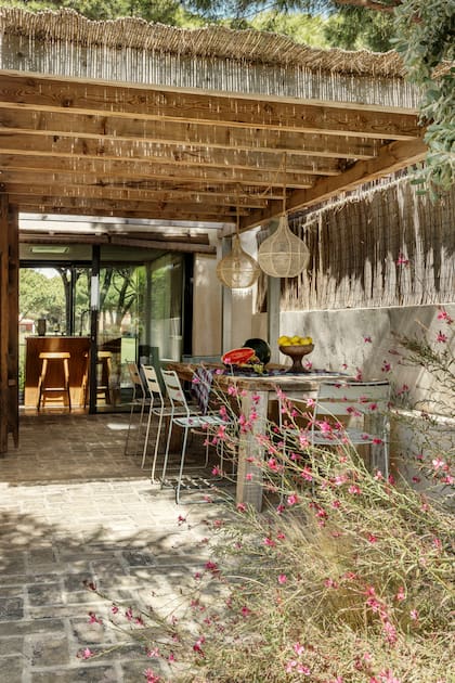 Bajo la pérgola de madera reciclada, sillas ‘Portofino’ (Isimar).