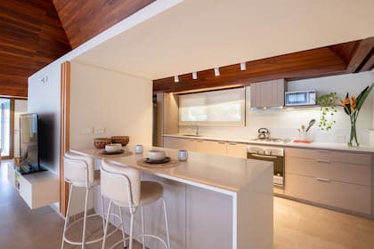 Bajomesada, alacena e isla de melamina 'Sahara' (Faplac) con mesada de Silestone 'Miami White' y banquetas a medida (todo diseñado por Siuk Studio).