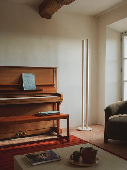 Banco de abedul '01' de Frama en lugar de un tradicional taburete de piano. Lámpara de pie 'L1', diseñada por Pierric de Coster para Valerie Objects.