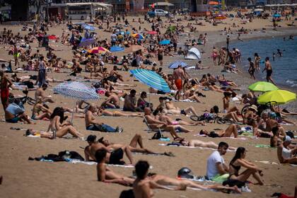 Bañistas toman el sol en una playa en Barcelona, el 8 de junio de 2021. (AP Foto/Emilio Morenatti)