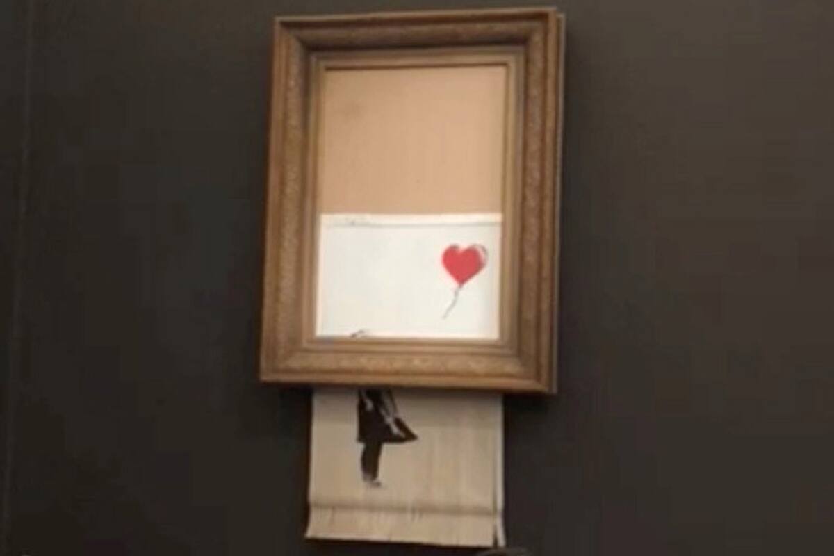 Banksys painting "Girl with Red Balloon" is seen shredded after its sale at Sotheby auction in London, Britain October 5, 2018 in this still image taken from a video obtained from social media on October 6, 2018. INSTAGRAM/@PIERREKOUKJIAN/INSTAGRAM/@SINCEFINEART via REUTERS