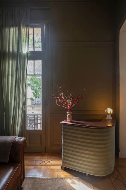 Bar hecho a partir de un mueble del Mercado de Pulgas que intervinieron con una tapa de mármol (UGO Mármoles Naturales). Florero de gres (Intervista) con arreglo (La Florería de José Ángel). Cortinas (Casa Almacén). Pisos originales, restaurados e hidrolaqueados.