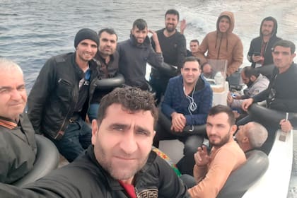 Baran Mesko se toma una selfie en un bote de pesca con una docena de otros migrantes kurdos sirios el sábado 15 de octubre de 2022, en ruta de Orán, Argelia, a España. (AP Foto/Baran Msko)