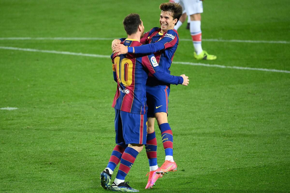 Barcelonas Argentinian forward Lionel Messi celebrates with Barcelonas Spanish midfielder Riqui Puig (R) after scoring a goal during the Spanish League football match between FC Barcelona and Deportivo Alaves at the Camp Nou stadium in Barcelona on February 13, 2021. (Photo by GENELLUIS / AFP)