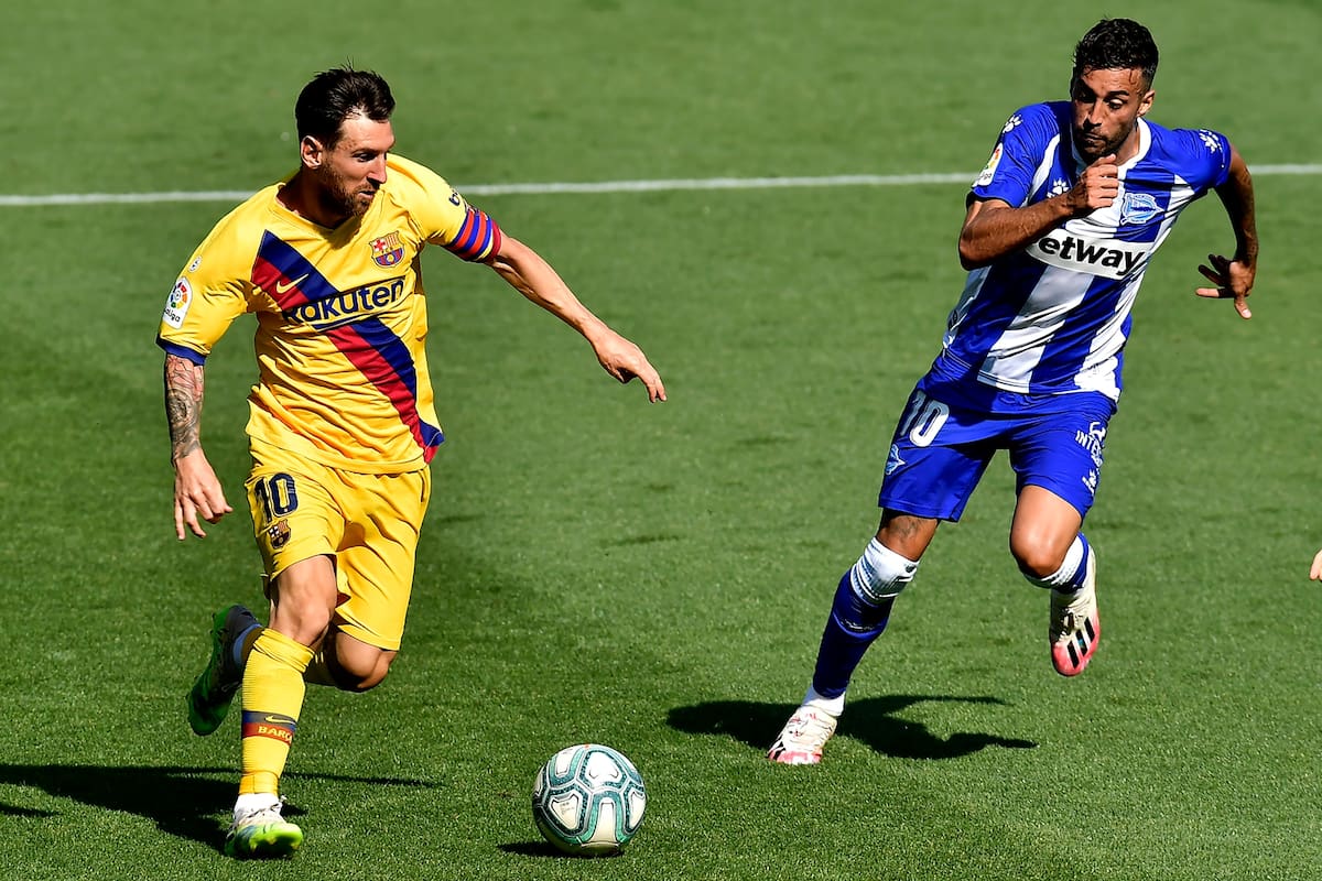 Barcelonas Lionel Messi, left, fights for the ball with Alaves Victor Camarasa during the Spanish La Liga soccer match between Alaves and FC Barcelona, at Mendizorroza stadium, in Vitoria, northern Spain, Sunday, July 19, 2020