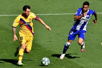 Barcelonas Lionel Messi, left, fights for the ball with Alaves Victor Camarasa during the Spanish La Liga soccer match between Alaves and FC Barcelona, at Mendizorroza stadium, in Vitoria, northern Spain, Sunday, July 19, 2020