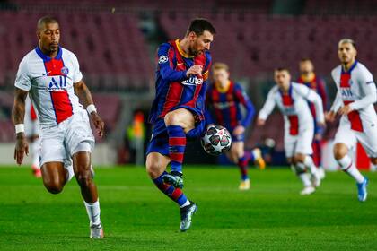Barcelonas Lionel Messi, right, duels for the balls with PSGs Presnel Kimpembe during the Champions League round of 16, first leg soccer match between FC Barcelona and Paris Saint-Germain at the Camp Nou stadium in Barcelona, Spain, Tuesday, Feb. 16, 2021. (AP Photo/Joan Monfort)