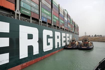 El enorme buque carguero encallado en Suez, un problema insoluble para las pequeñas embarcaciones que intentan destrabarlo