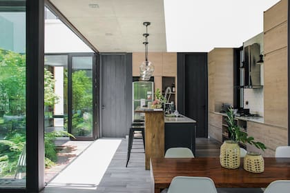 Barra de petiribí y muebles de melamina ‘Roble Escandinavo’ de Faplac, todo diseño del Nodo Arquitectura. Anafe (Franke). Horno (Domec). Campana (Spar).