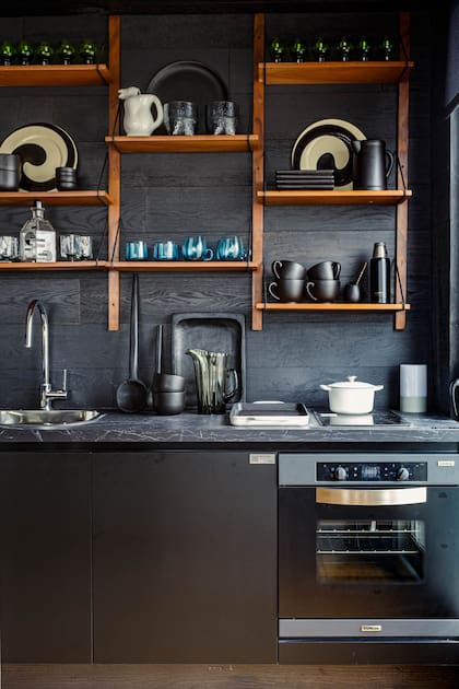 Barra y mesada de Dekton 'Somnia' (Canteras). Alzada de madera (Patagonia Flooring). En la estantería (Casa Superí), vasos de vidrio soplado, piezas de barro y platos de Murano italianos de los años '70 (Damax).