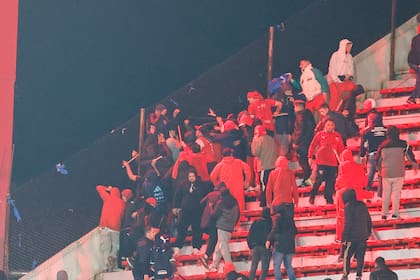 Barrabravas de Independiente atacan a hinchas de Universidad de Chile que se guarecen detrás del alambrado, con el vacío por debajo; Gonzalo Alfaro cayó varios metros y se lastimó gravemente.