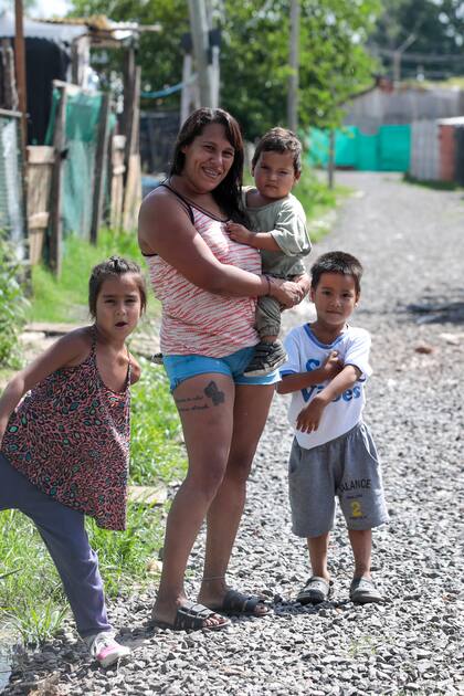 Lara Cabrera, junto a sus hijos, en una de las calles de piedra del barrio Vicente López, de Pilar, uno de los que fue incorporado al registro