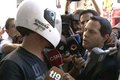 Bebote en la puerta del club con un casco de moto