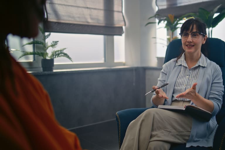 Beginning of psychotherapy: female psychotherapist starts therapy with African American teenager. Therapist talks to teen boy, asks questions to find out problems. Psychology and psychotherapy.