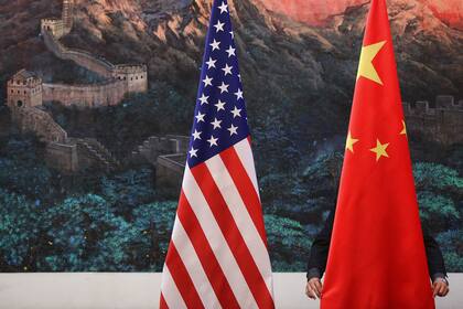 BEIJING, CHINA - SEPTEMBER 05: A Chinese man adjusts a Chinese flag before Chinese Foreign Minister Yang Jiechi and US Secretary of State Hillary Clinton's press conference at the Great Hall of the People in Beijing on September 5, 2012. (Photo by Feng Li/Getty Images)