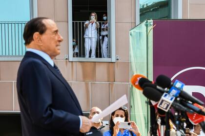 El personal médico toma fotos del exprimer ministro italiano Silvio Berlusconi mientras se dirige a los medios de comunicación, cuando sale del Hospital San Raffaele en Milán