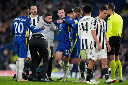 Ben Chilwell, centro, del Chelsea, es atendido durante el partido frente a la Juventus por el Grupo H de la Liga de Campeones, en el estadio Stamford Bridge de Londres, el martes 23 de noviembre de 2021. (AP Foto/Matt Dunham)