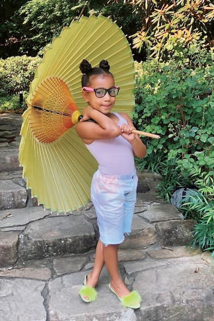 Bermuda, musculosa, zapatitos de muñeca y sombrilla oriental durante unas vacaciones familiares.