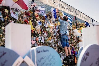 Bernardo Camou coloca un rosario en una cerca conmemorativa para su hermana y su esposo, quienes se encontraban entre las 98 personas que murieron.