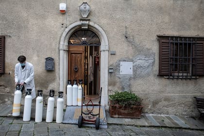 Berti, un farmacéutico local, alinea botes de oxígeno vacíos en la parte trasera de una farmacia para ser reemplazados por otros llenos, en el pueblo toscano de Castellina in Chianti, en Italia, el 17 de diciembre de 2020. Cuesta 10 veces más que entregarlo a granel