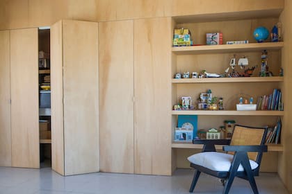 Biblioteca y placard de madera plegable: toda una pared dedicada al guardado.