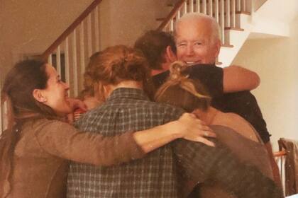 Biden entre una montaña de abrazos con sus cinco nietos