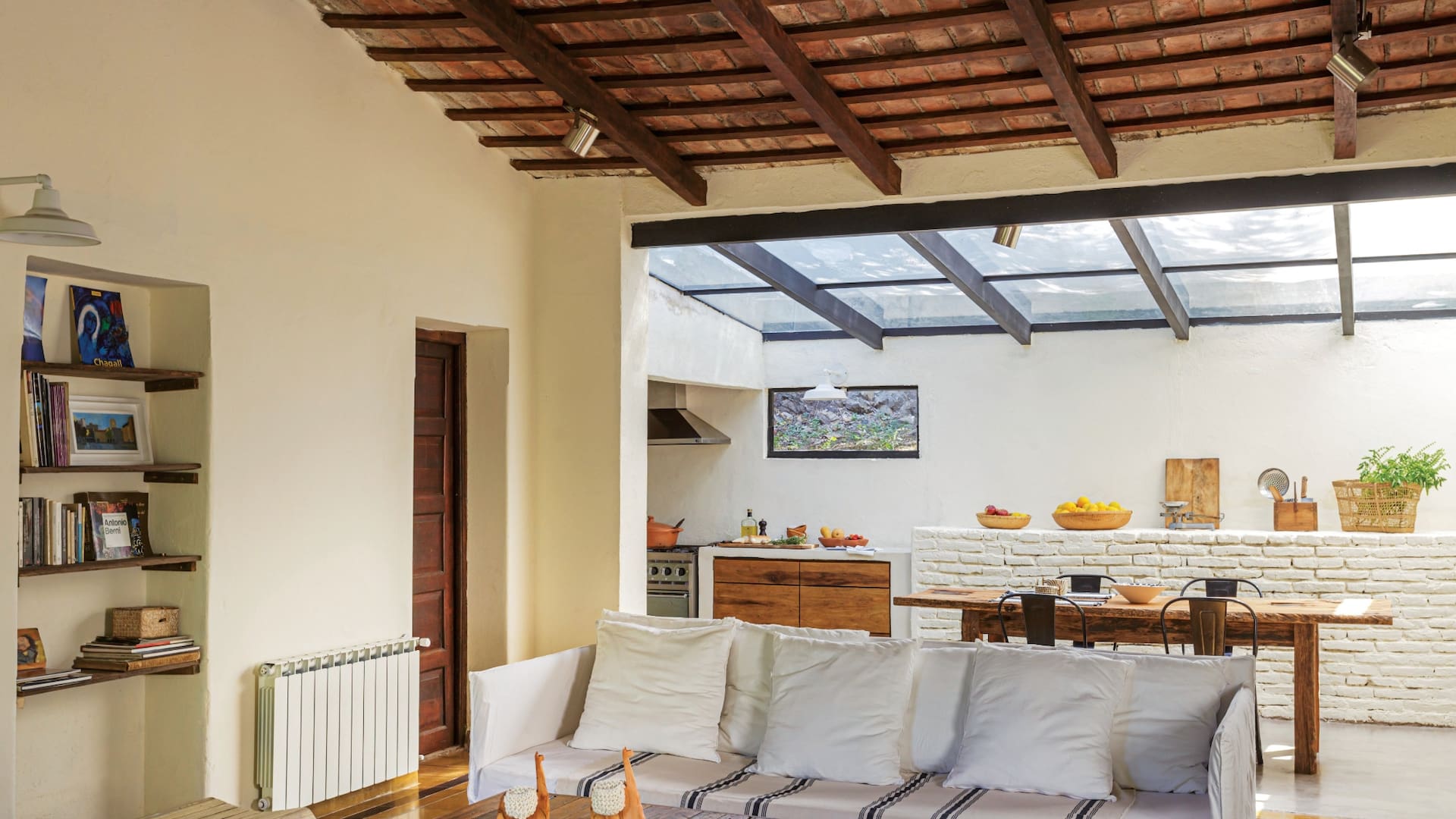 Bien camperas, las lámparas de latón pintado que rodean la construcción se llevaron al interior: están junto a la biblioteca, sobre el área de trabajo de la cocina, y se volverán a ver en el baño, adecuadamente complementadas por artefactos sutiles pero potentes.