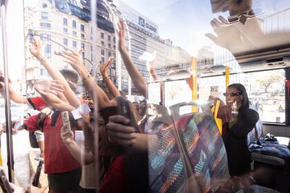 Biles se graba mutuamente con los entusiasmados estudiantes que se acercaron al micro en el que la gimnasta llega al Obelisco.