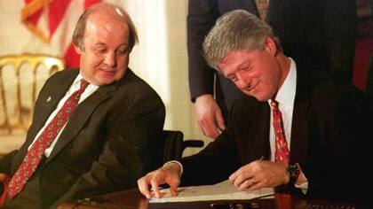 Bill Clinton firmando la Ley Brady en noviembre de 1993, al lado de James Brady, que recibió un disparo en 1981 durante el intento de asesinato de Ronald Reagan.