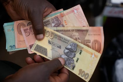 Billetes de diversas denominaciones de dólar zimbabuense en las calles de Harare, Zimbabue, el 9 de junio de 2022. (AP Foto/Tsvangirayi Mukwazhi, Archivo)