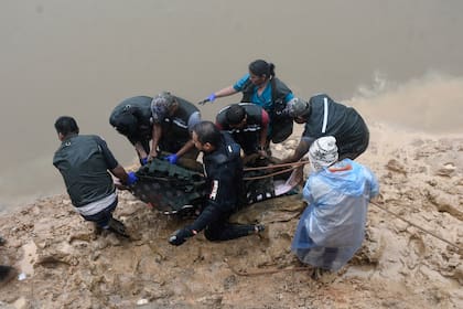 Biólogos y activistas medioambientales liberan a un delfín rosado en el río Isiboro, en las afueras de Villa Tunari, Bolivia, el viernes 24 de mayo de 2024. Una hembra y su cría de siete meses fueron rescatadas de un arroyo con bajo caudal donde quedaron atrapadas por un mes. (Daniel James/Los Tiempos vía AP)
