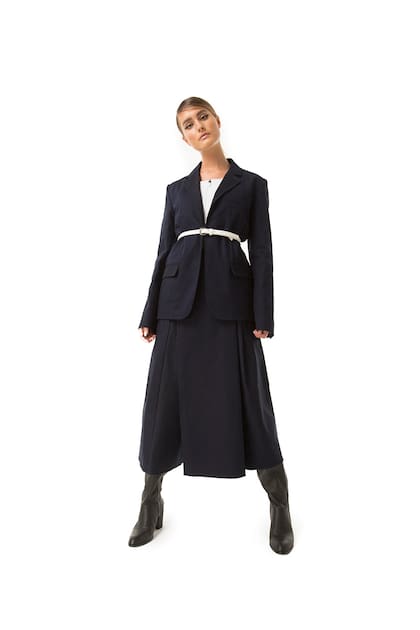 Blazer con cordón regulable y pollera pantalón tableado de jean (JT), top deportivo con cierre (Adidas), botas bucaneras de cuero y cinturón de cuero (Prüne)
