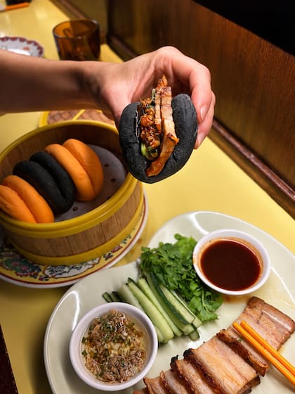 Bloody Baos, rellenos de cerdo jugoso y char siu, y una porción de Hallo Baos, panes al vapor negros y anaranjados que podrán combinarse con cualquiera de las preparaciones habituales de la carta
