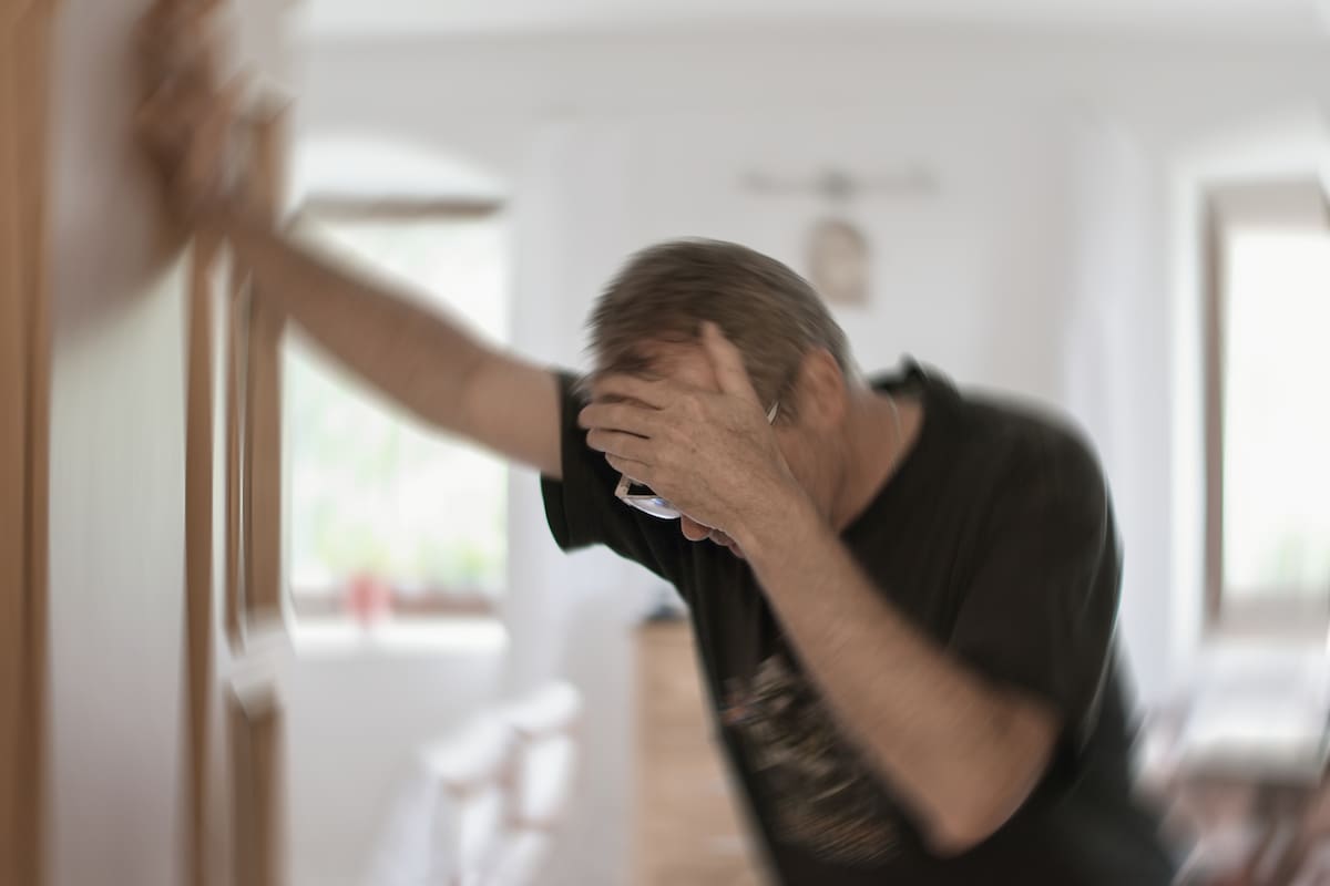 Blured photo of a man suffering from vertigo or dizziness or other health problem of brain or inner ear.