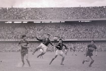 Boca-San Lorenzo, en la Bombonera, el 14 de julio de 1956: Sanfilippo en el aire, en busca de la pelota; a la izquierda, lo observa Antonio Rattín