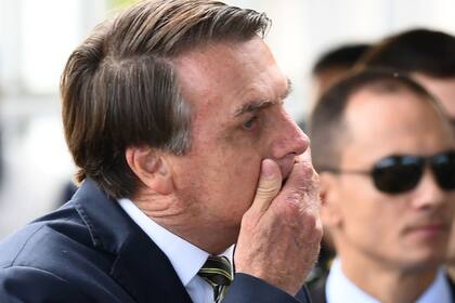 Bolsonaro se tapa la boca, ayer, al salir del Palacio de la Alvorada, en Brasilia