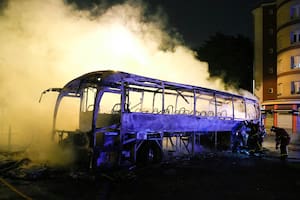 Bomberos arrojan agua a un autobús quemado, el sábado 1 de julio de 2023, en Nanterre, en las afueras de París, Francia.