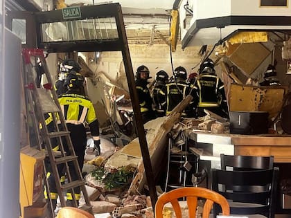 Bomberos en el bar destrozado por la explosión