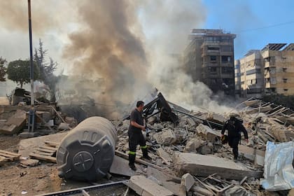 Bomberos inspeccionan las ruinas de un edificio tras un bombardeo israelí en Beirut, Líbano