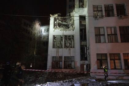 Bomberos inspeccionan los daños en un edificio de oficinas después de que fuera alcanzado por bombas planeadoras rusas en el centro de Járkiv, Ucrania, el lunes 28 de octubre de 2024. (AP Foto/Efrem Lukatsky)