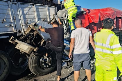 Bomberos intentan rescatar al conductor de uno de los camiones