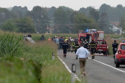 Bomberos sellan el área donde un auto fue impactado por un avión del equipo aéreo acrobático italiano Frecce Tricolori durante un vuelo de práctica en Turín, Italia, el sábado 16 de septiembre de 2023. (Matteo Secci/LaPresse vía AP)